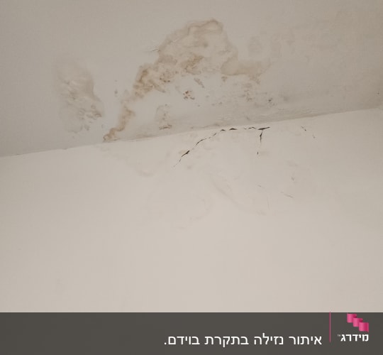 כתמי רטיבות וסדקים בתקרה לבנה
